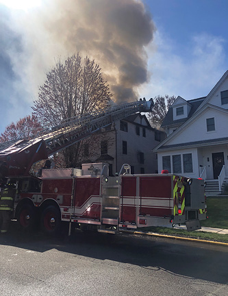 A tower ladder positioned between dwellings offers access into the floors of the fire building for water application and search operations. In addition, it can protect the exposure from radiant heat.