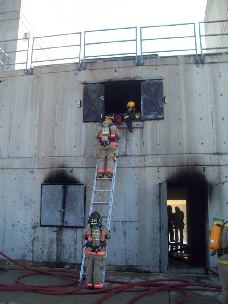 Firefighter footing the ladder at burn building