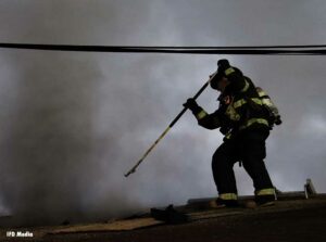 Indianapolis firefighter on roof with a hook