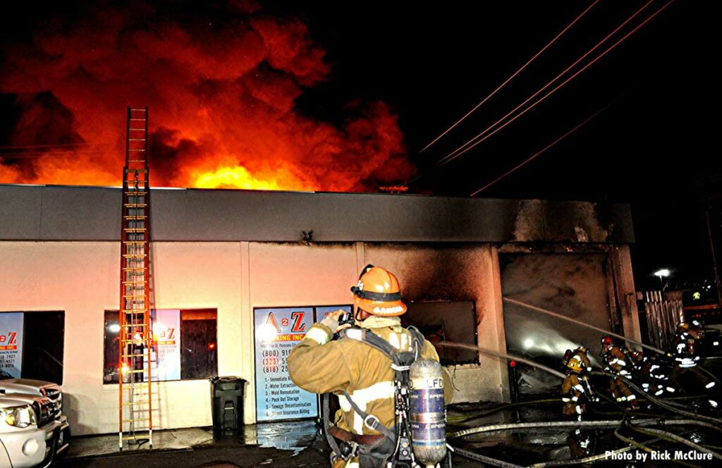 Ladder to the roof of a building with firefighters working