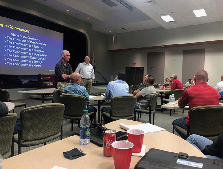 (1) (Left to right) Fire Engineering Editor in Chief Bobby Halton and Fire Department of New York Captain (Ret.) Mike Dugan teach as veteran Miami-Dade (FL) Fire Rescue Captain Bill Gustin (in red shirt, far right front) takes notes. (Photos by author.) 