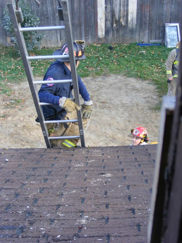 Firefighter on a ground ladder seen from roof