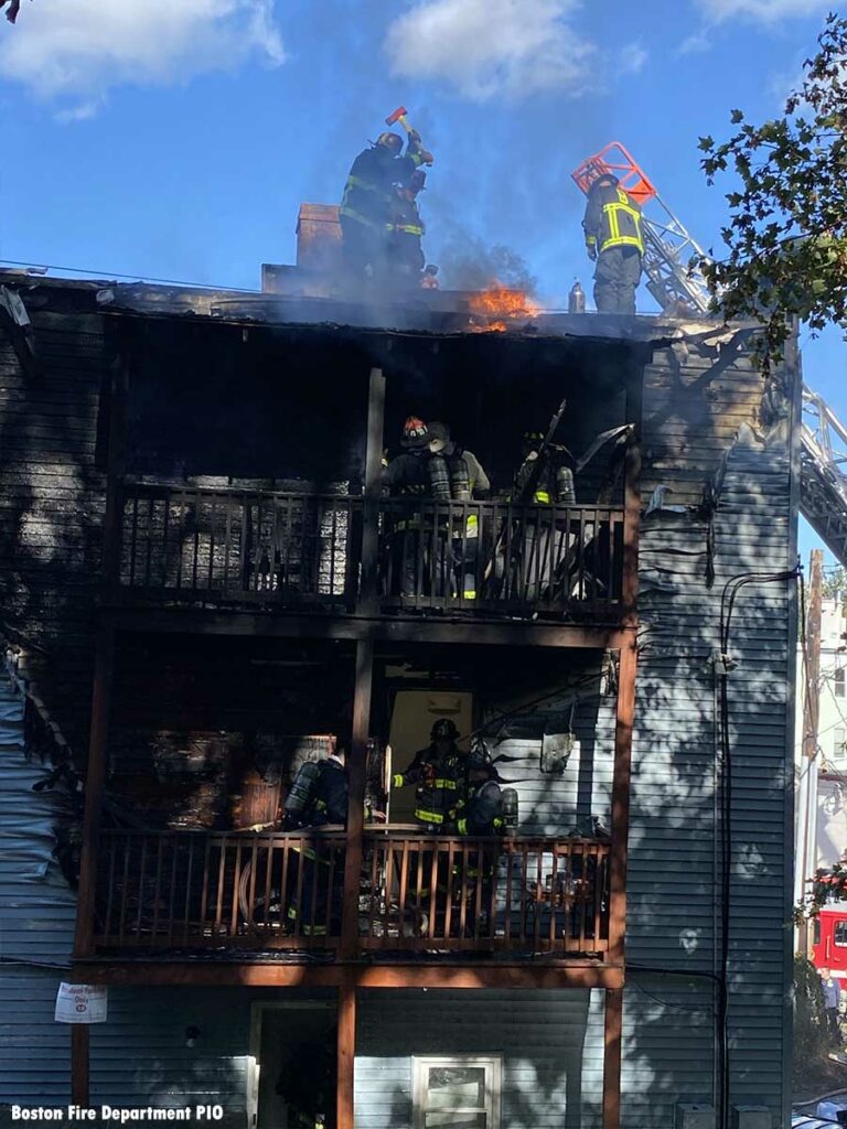 Flames along roofline as Boston firefighters work