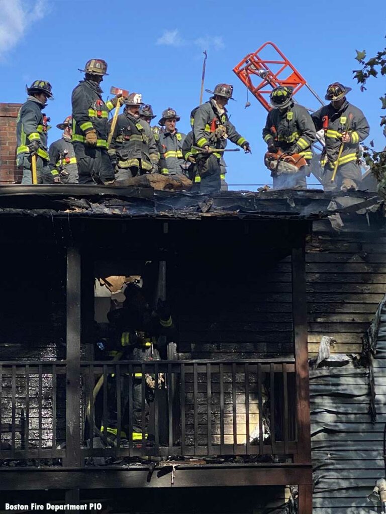 Boston firefighters working on roof at fire