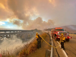 Firefighters extinguish flames near California highway