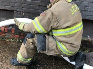 Firefighter maneuvering hoseline