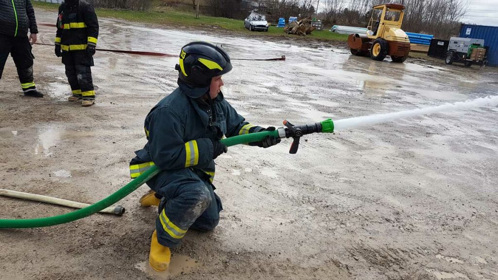 Firefighter in Euro helmet flowing water