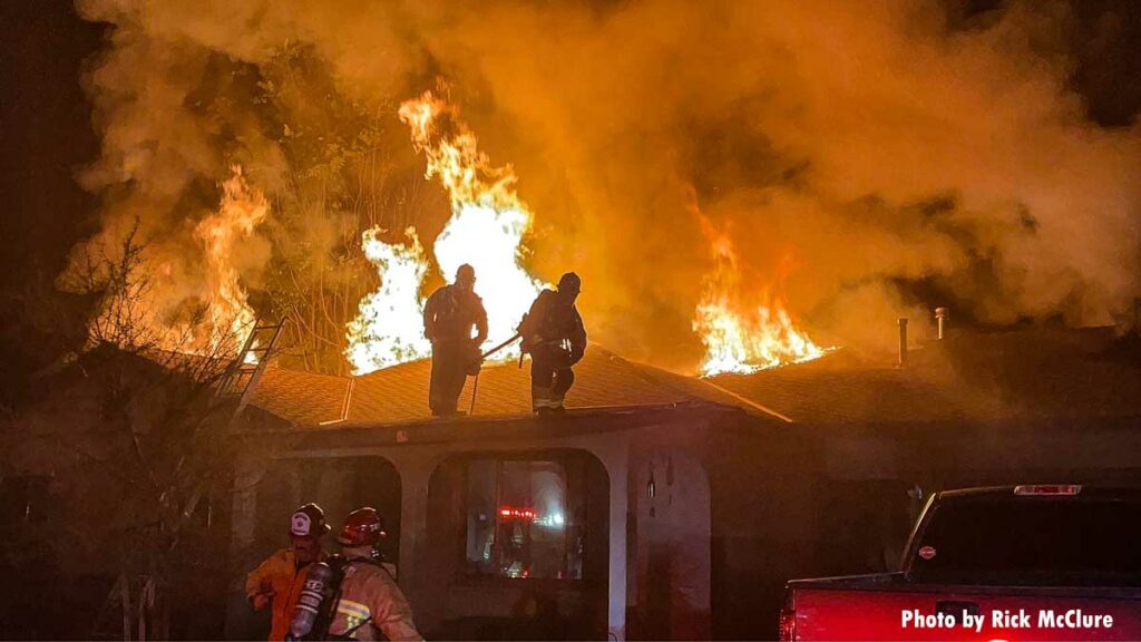 Two firefighters in front of flames