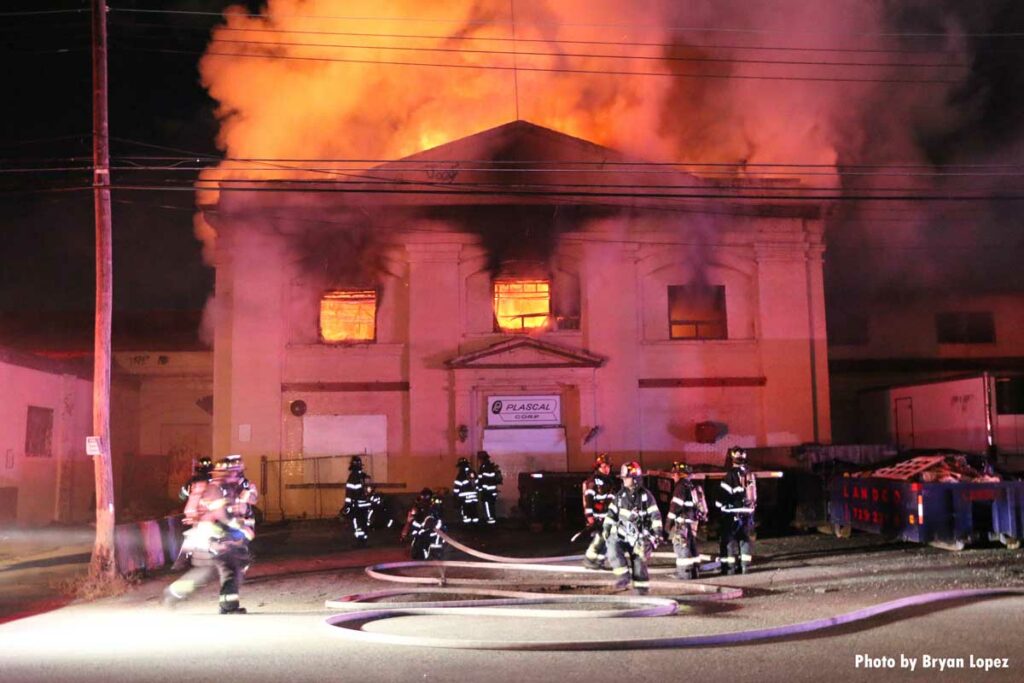 Firefighters with hoselines at four-alarm Long Island fire