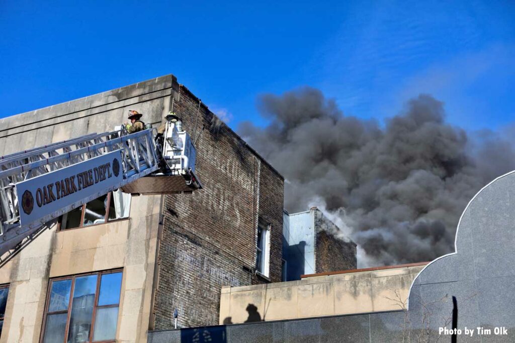 Firefighters in tower ladder and dark smoke