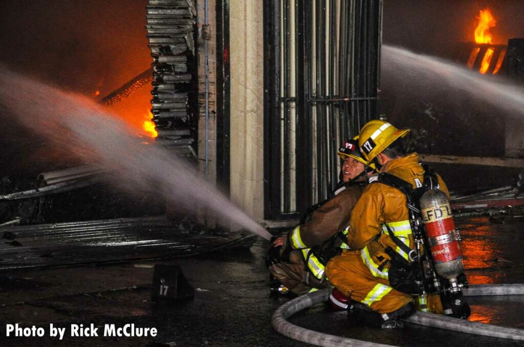 Two firefighters on portable master stream talking