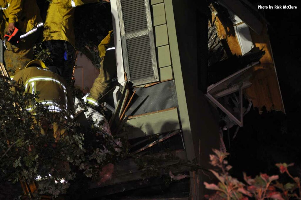 Firefighters and tree that fell on home