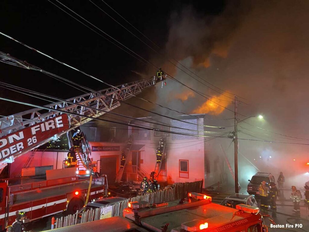 Boston Fire Ladder 26 with aerial extended over burning building