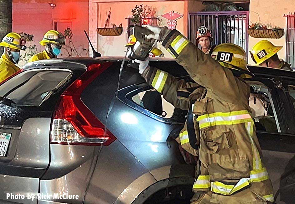 Firefighter uses extrication tool on car