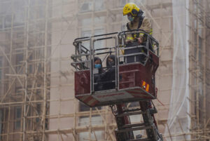 Firefighter with victims in bucket