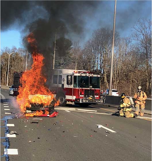 Firefighters confront vehicle fire