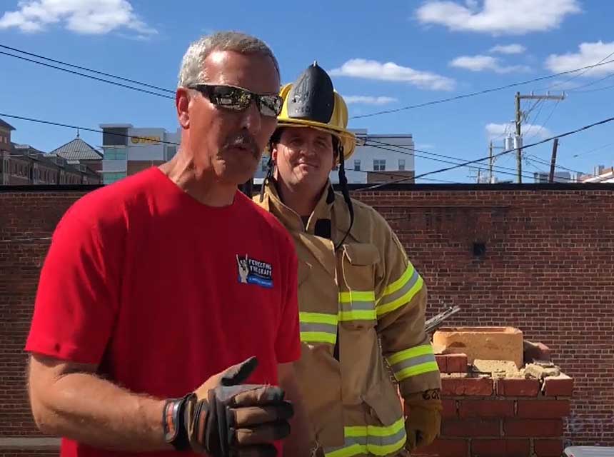 Mike Ciampo and a firefighter talking hooks and tools