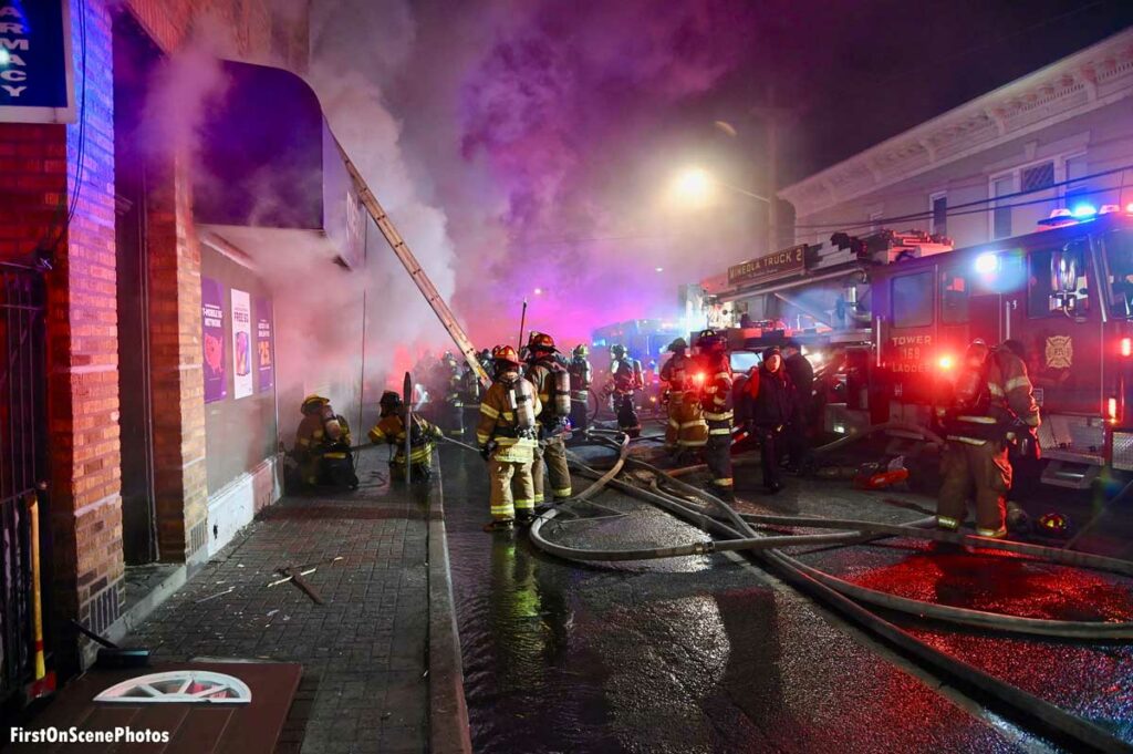 Ladders, smoke, and firefighters at Mineola NY commercial fire