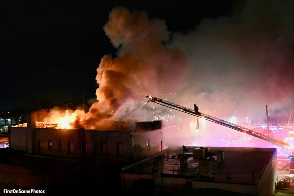 Firefighter on aerial ladder and elevated stream