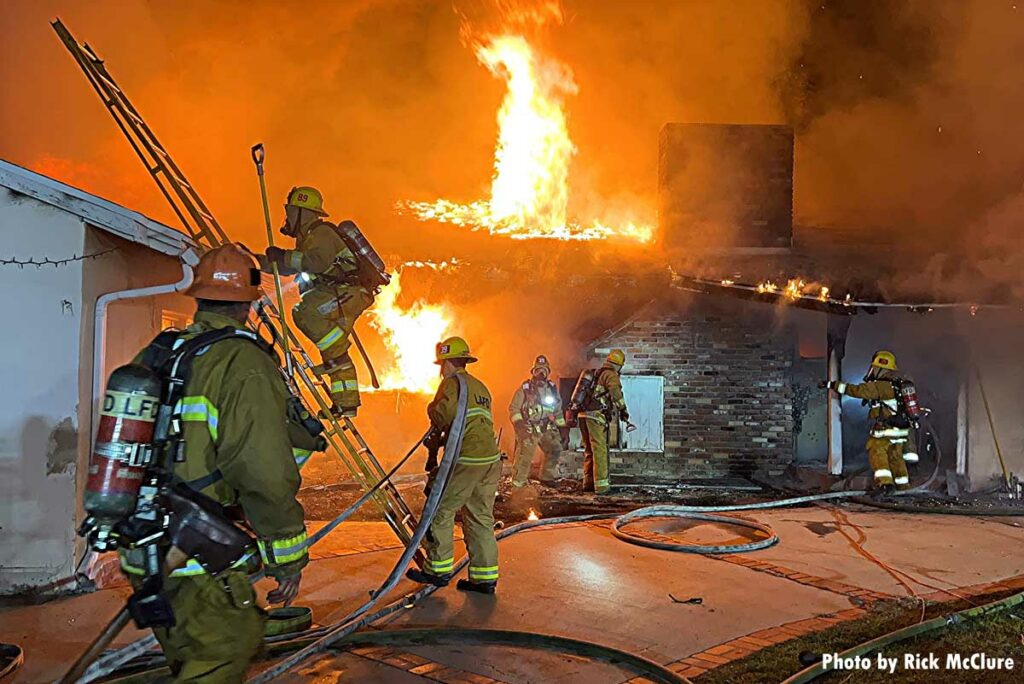 LAFD crews working at house fire with flames through the roof