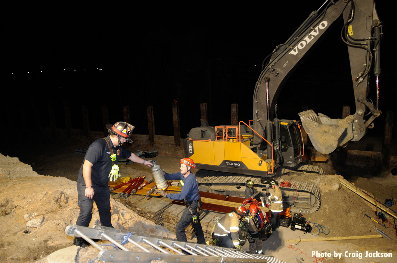 Firefighters with ladder and excavator