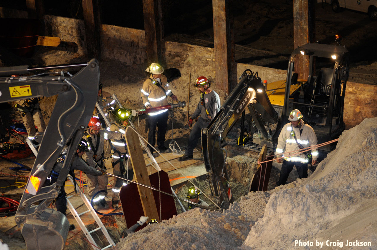 Firefighters with mini excavators at trench rescue