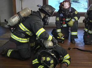 Firefighters assess a down firefighter