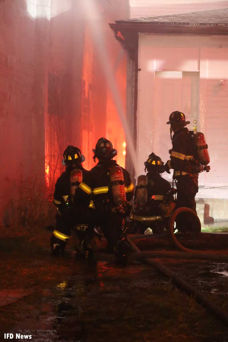 Four firefighters with hoseline at Indianapolis fire