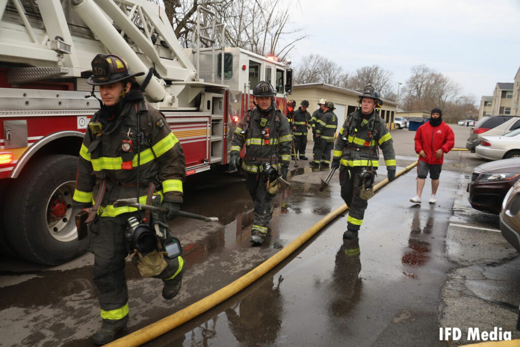 Indianapolis firefighters with tools and supply line