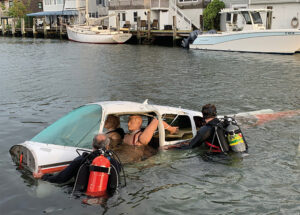 Firefighters with victim dummy in sinking car