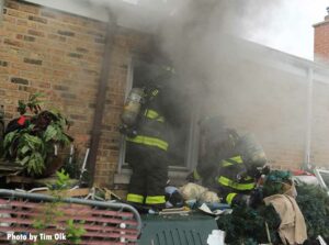 Amid smoke Chicago firefighters work at a fire in a ranch home 5812 N Oriole May 2021