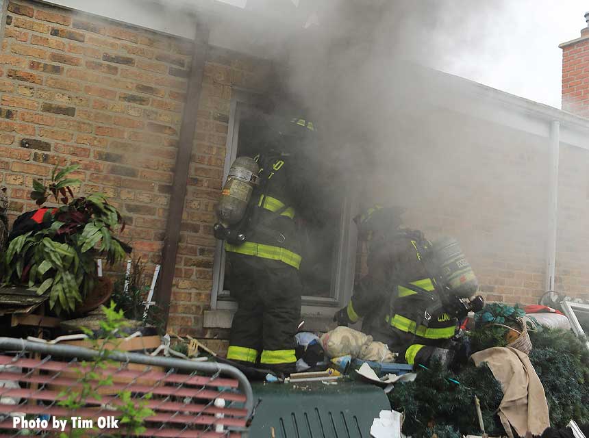 Amid smoke Chicago firefighters work at a fire in a ranch home 5812 N Oriole May 2021