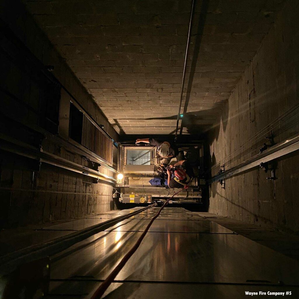 Firefighter removing trapped victims in elevator rescue