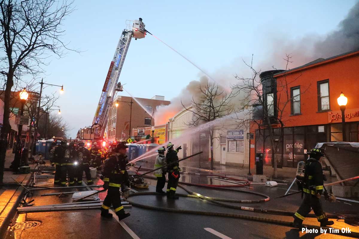 Chicago firefighters on street direct streams into burning buildings