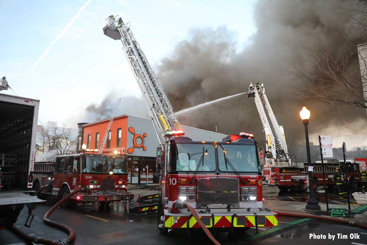 Multiple Chicago tower ladder fire trucks put water on fire