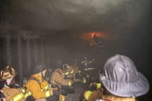 Firefighters inside flashover container during FDIC hands-on training