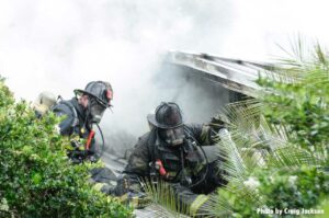 Firefighters amid smoke and trees at Orlando house fire