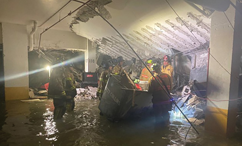 Crews working in the underground parking garage. Gasoline is floating on top of the standing water.