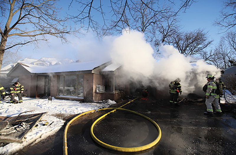 There are three handlines here—the first is in the front door of the home to protect the structure, the second is in the garage to extinguish the fire, and the third is going to the rear of the structure to extinguish the fire in the rear of the building.