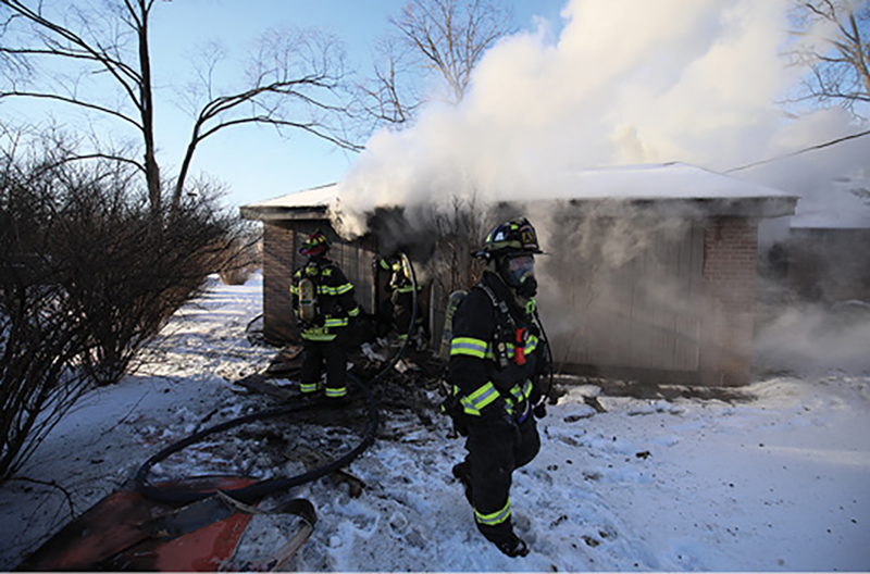 The fire in the rear of the building is being extinguished by the line in the rear yard.