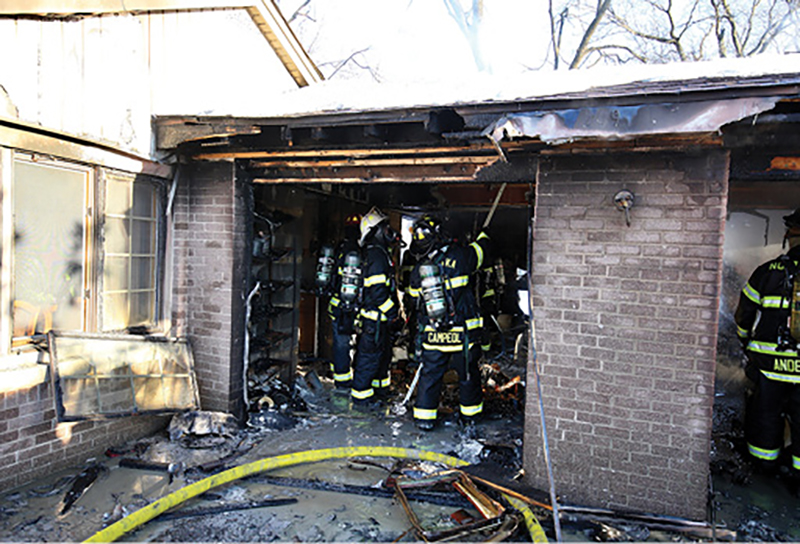 Members overhaul the garage. The damage to the main house is minimal because of the presence of a fire rated assembly between the garage and the main part of the structure.