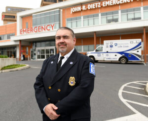 A man poses in front of a hospital.