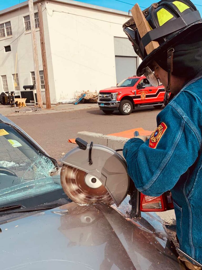 Firefighter performing an alternative method for gaining access to the engine compartment