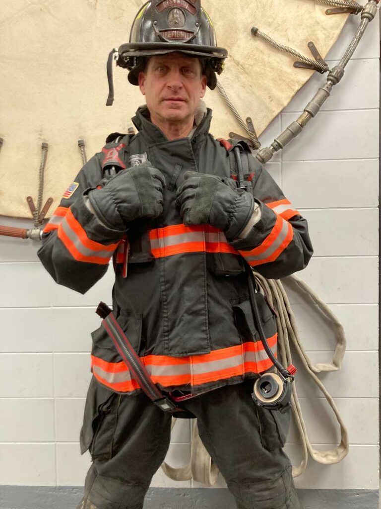 Firefighter adjusts gear for impending rescue