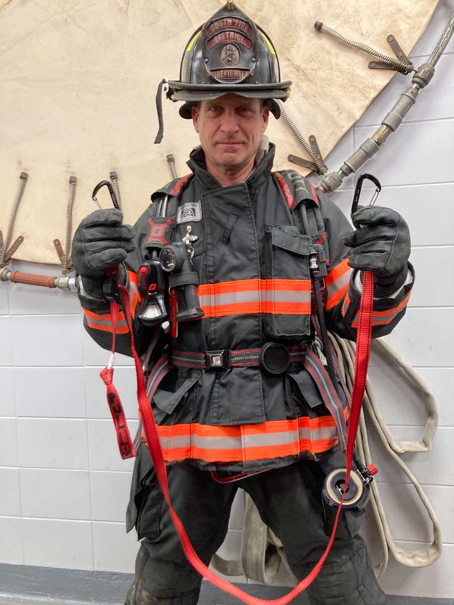 Firefighter with carabiners and strap