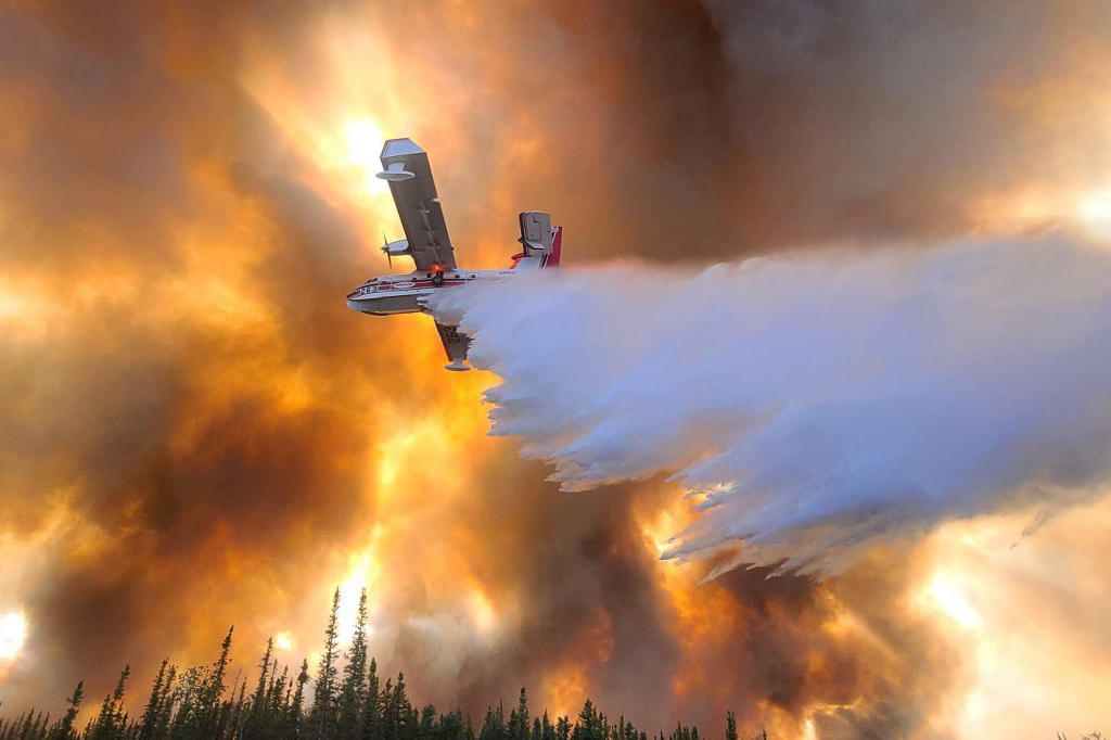 A fixed-wing aircraft drops water on the Clear Fire near Anderson, Alaska, on July 6, 2022.