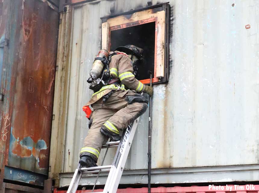 Firefighter climbs a ladder during FDIC 2022 training