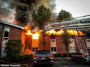 Flames rip along roof as aerial puts water into building