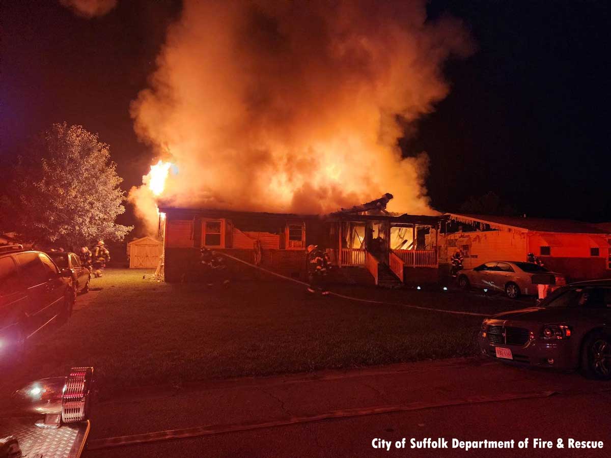 Firefighters pulling hoselines at Suffolk VA house fire