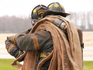 Firefighter with hose slung over shoulder